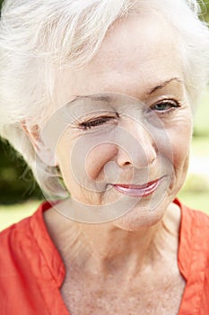 Head And Shoulders Portrait Of Winking Senior Woman