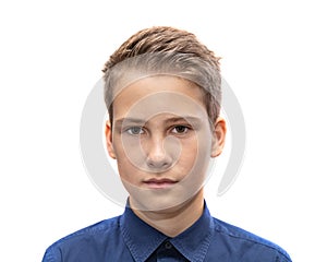 Head and shoulders portrait of a young 11 year old boy with brown eyes and dark hair in a good mood with a smile