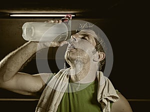 Young attractive and handsome sport man at fitness club sweating after workout hard training looking defiant with towel on his photo