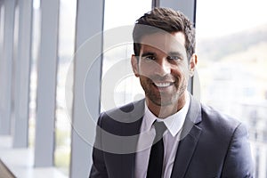 Head And Shoulders Portrait Of Young Businessman In Office
