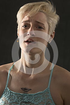 Head and shoulders portrait of young woman in great pain.