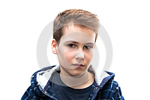 Head and shoulders portrait of a young 11 year old boy with brown eyes and dark hair in a good mood with a smile