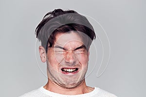 Head And Shoulders Studio Shot Of Man Pulling Faces And Smiling At Camera