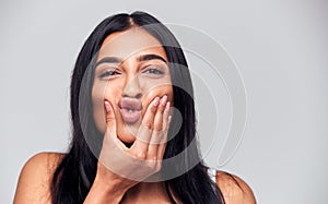 Head And Shoulders Studio Shot Of Woman Pulling Faces And Smiling At Camera