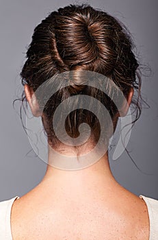 Head and shoulders of a young woman from the back side. Female h