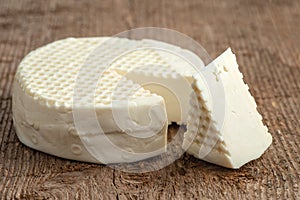 Head and slice of brined cheese, bryndza, on a wooden background