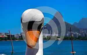 Head of a white Swan Pedal Boat with blurry Rodrigo de Freitas Lagoon and Dois Irmaos Mountain on the background