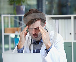 Headache, burnout or doctor with stress in a hospital thinking of emergency, medical deadline or pressure. Migraine, man