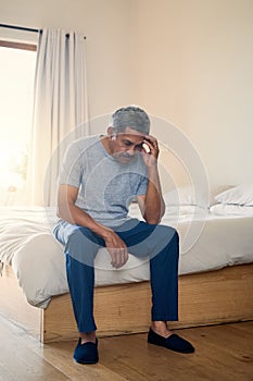 This headache is getting really irritating. a stressed out mature man holding his head in discomfort while being seated