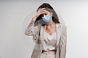 Headache girl in blue medical mask. Woman touches her head because sicks coronavirus covid-19. Pandemic 2020. photo