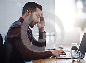 This headache is just the most frustrating. a young businessman looking stressed out while working in an office.