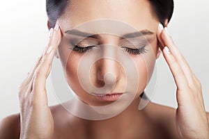 Headache, migraine and stress. A woman worries about a woman who suffers from headaches. On a gray background. Holds his hands to