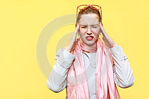 Headache or pain. Distressed woman holding hands on head and cl