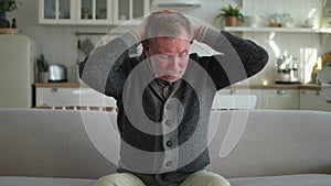 Headache pain. Unhappy middle aged senior man suffering from headache sick rubbing temples at home. Mature old senior