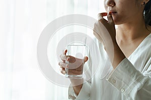 Headache women take medicine with a glass of water, healthcare and medicine recovery concept photo