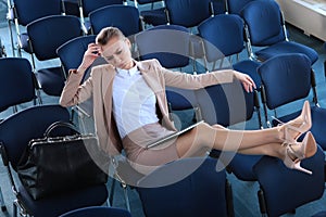 A headache for a young businesswoman. A girl in a business suit sits alone in an empty conference room. Copy of the space.Top view