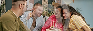 Header Image of Multiethnic Young Adults Celebrating Birthday with Cake at Home photo