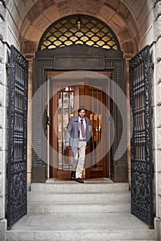 Heading home at the days end. A view of a businessman leaving work through an ornate doorway.