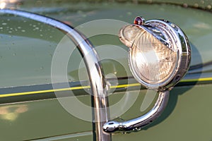 Headlamp and chrome detail on hood of vintage classic oldtimer car