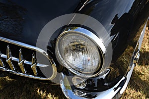 Closeup of the front of a black classic 1950`s car