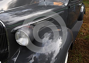 The headlamp, grill and fender of a 1938 automobile