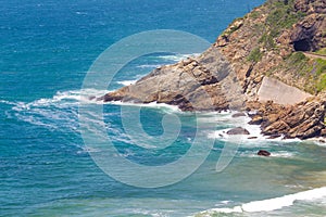 Headland jutting into the sea with railway tunnel and tracks next to bay