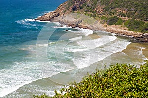 Headland jutting into the sea with railway tunnel and tracks next to bay photo