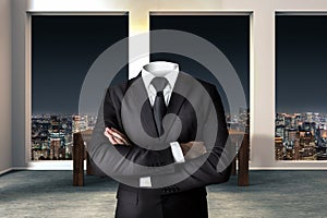 Headless businessman with crossed arms in modern urban office