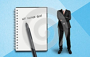 Headless businessman and notepad with German message