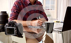 Headless crop of a photographer at his home workspace