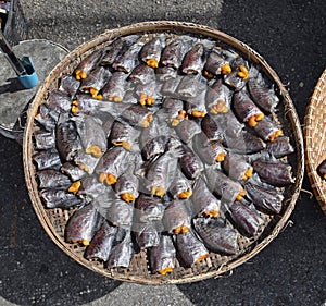 Headless dried fish called Pla Salit on round bamboo basket