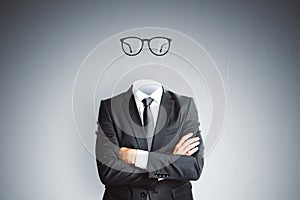Headless invisible businessman in suit with folded arms and abstract glasses standing on gray wall background. Business and secret