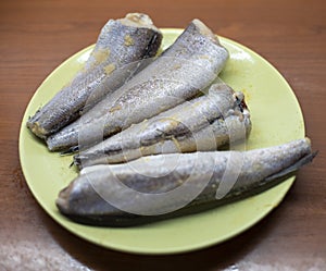 Headless raw hake fishes on plate