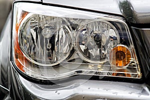 Headlight closeup of grey sporty car