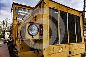 Headlight and front part of an old abandoned broken road construction machine