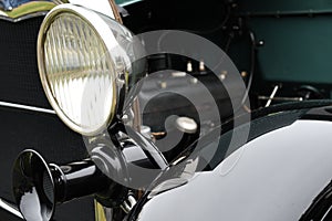 The headlight and horn of an antique automobile