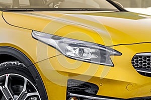 Headlight lamp of new cars. Close up detail on one of the LED headlights modern yellow car. Exterior closeup detail. Closeup headl