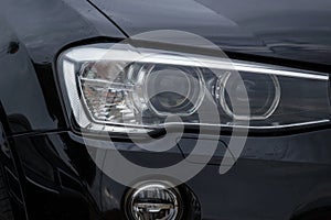 Headlight of a modern prestigious black car close-up