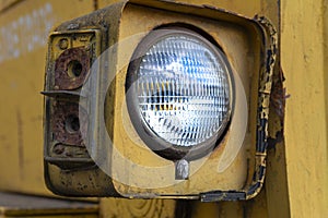 Headlight of an old abandoned broken road construction machine