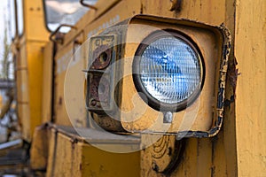 Headlight of an old abandoned broken road construction machine