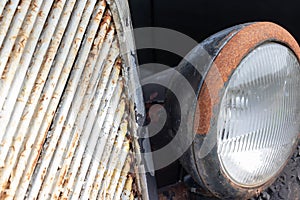 Headlight of an old rusty abandoned car, utilisation and scrap concept