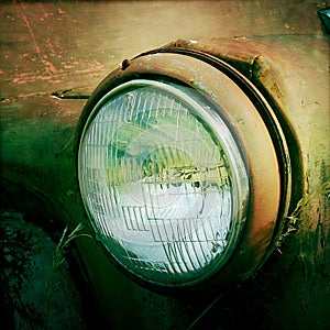 Headlight of and old vintage car left to rot in paddock
