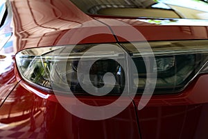 close up headlight of red car, transportation industry