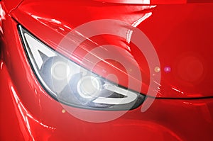 Headlight of a red sports car.