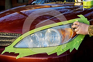 Headlight restore in the worker polishes optics of headlights of the car with the hand tool