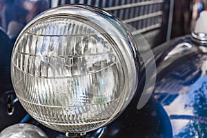 Headlight of a vintage retro old car automobile vehicle.