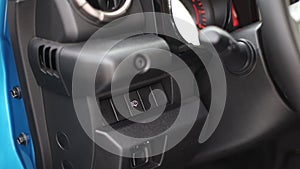 Headlight washer button in the interior of a modern car.