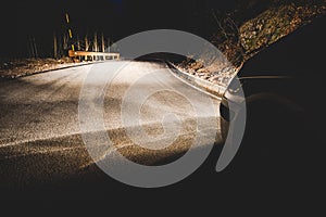 The headlights of a car on mountain road in the night