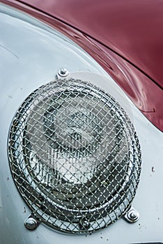 Headlights with protective grille an oldtimer Porsche 356 Carrera Speedster GT during a rally