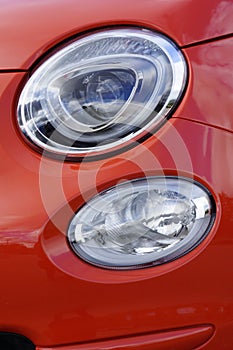 Headlights in a red classic Italian Fiat 500 cars